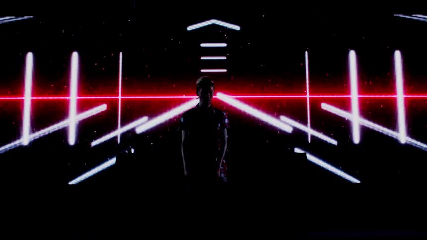 A man performs in front of a projection screen
