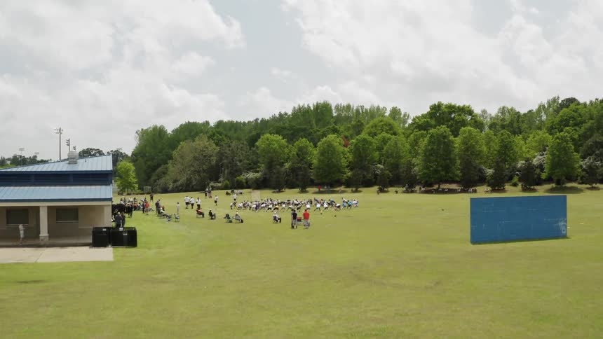 People are gathered on a soccer field on a cloudy day