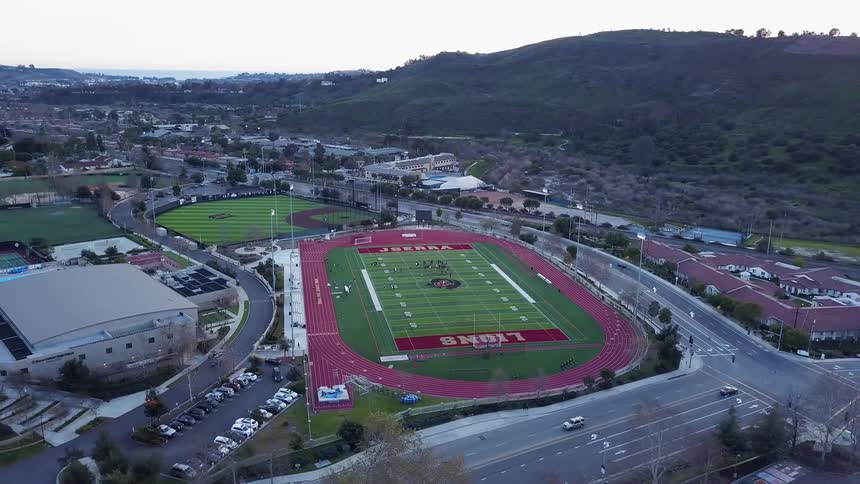 Cars drive by a football field
