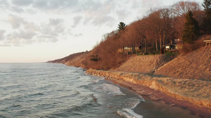 Waves flow towards a shoreline at sunset