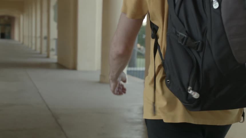A man walks with a backpack
