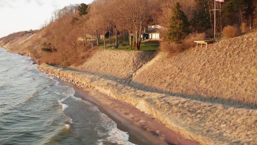 Water crashes into shore under a cloudy sky
