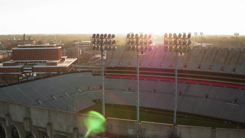 Sunlight is streaming down onto an empty football stadium