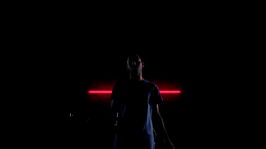 Men perform in the dark in front of the red lights