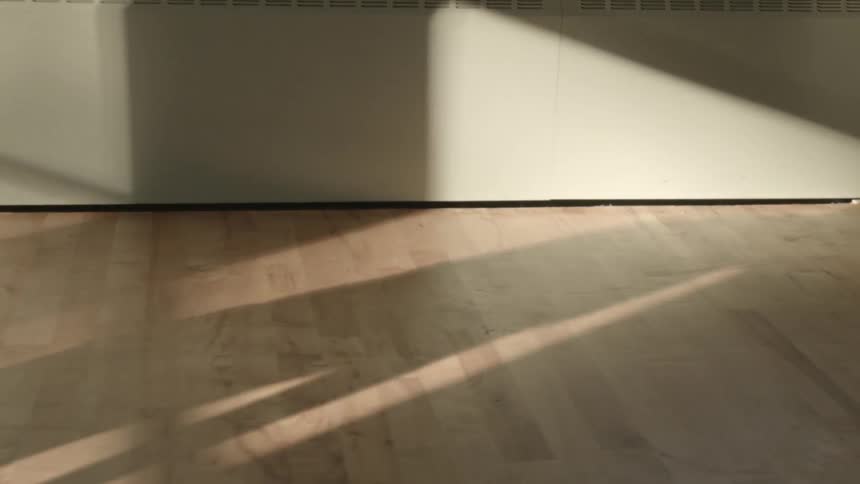 A dancing man's shadow is cast on the floor and wall