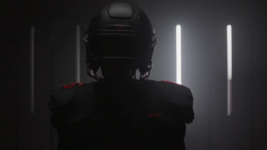 A football player is in the dark by flashing lights