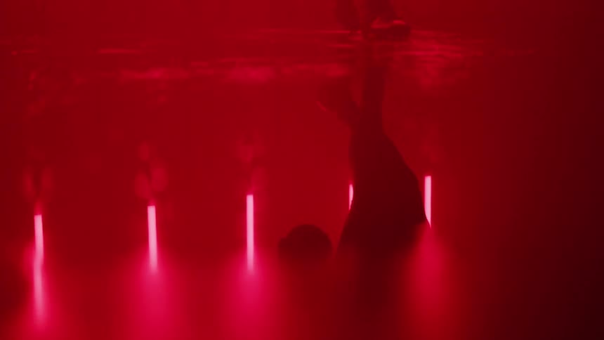 A football player walks in a room with red lights