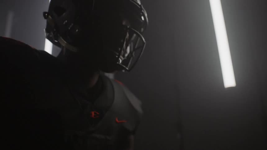 Football player standing in strobe lit room