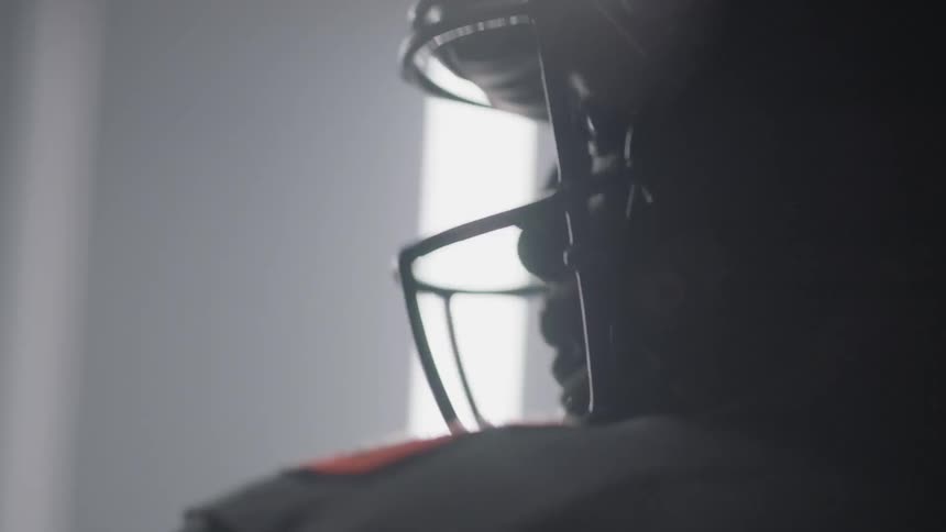 The football player stands in front of the flashing lights