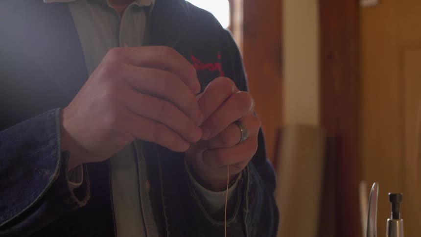 A man threads a needle