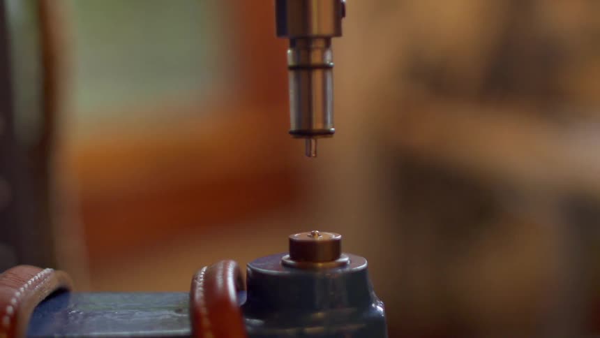 A man uses a tool in a workshop