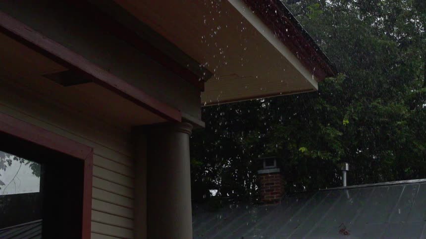 Rain pours of the edge of the roof