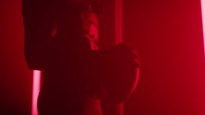 A football player holds a football while red lights flash