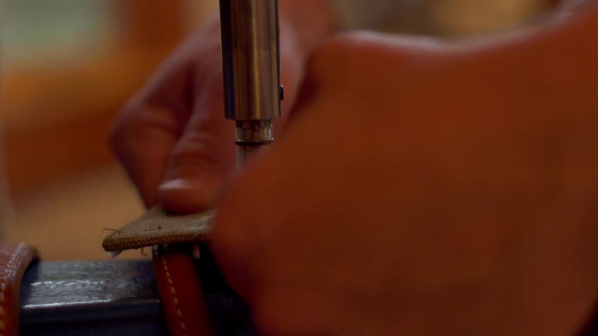 Man uses a machine to insert a rivet