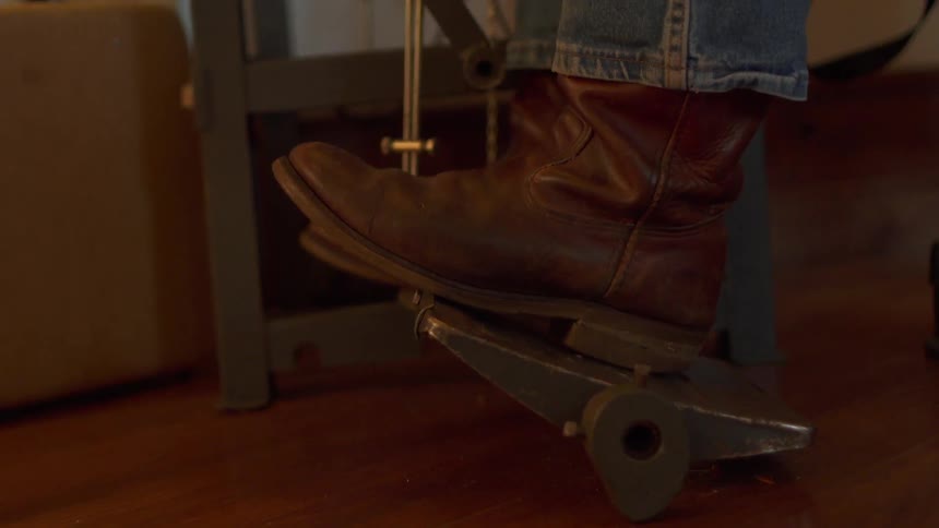 A man rests his boot on a foot pedal