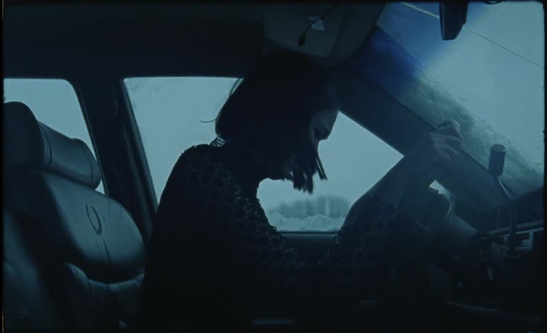Woman is sitting in car and crying on cold winter evening