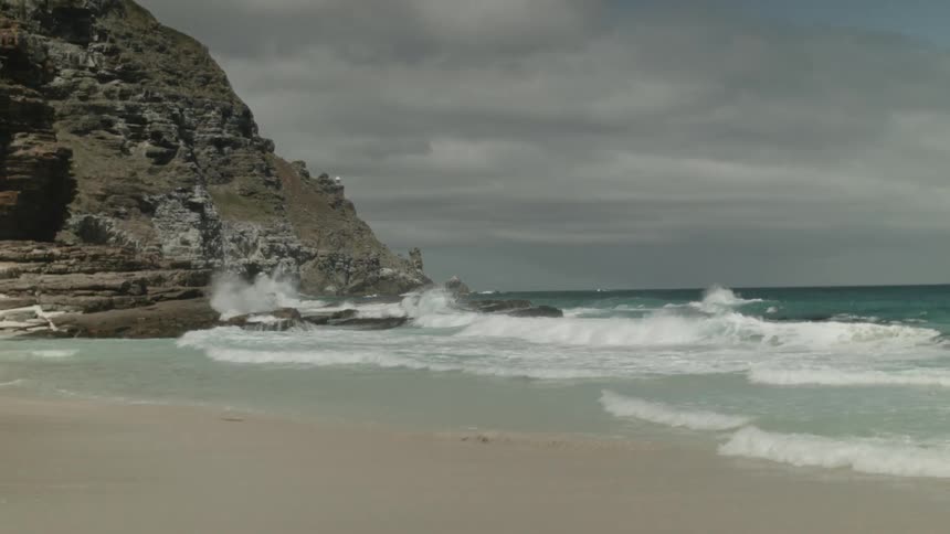 Waves crash on the beach on an overcast day