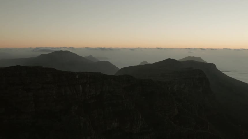 The sun sets over a mountain range