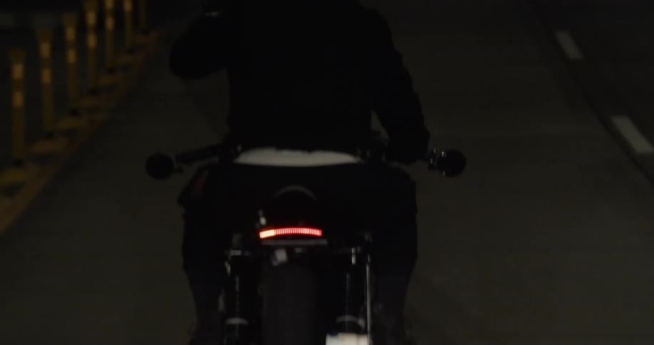 Person riding motorcycle on street at night