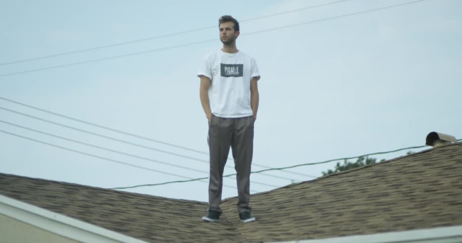 The man stands on the roof looking around