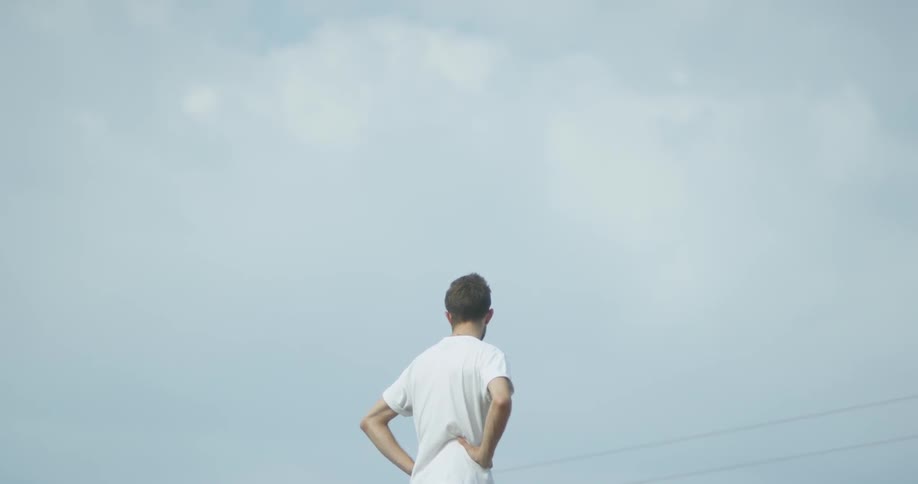 A man stands outside under blue skies