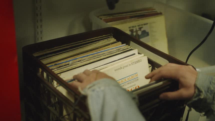 A person flips through some records