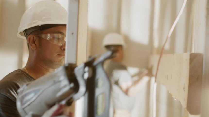 A man is using a nail gun