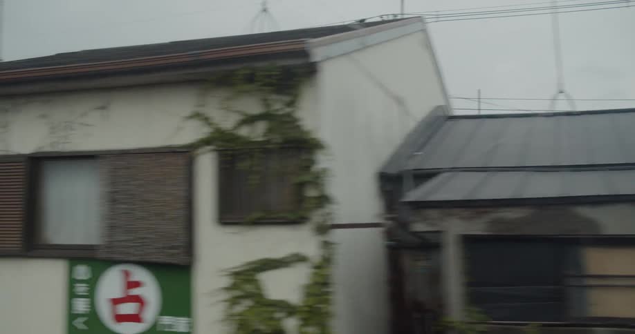 Passing houses and apartment buildings in city on cloudy day