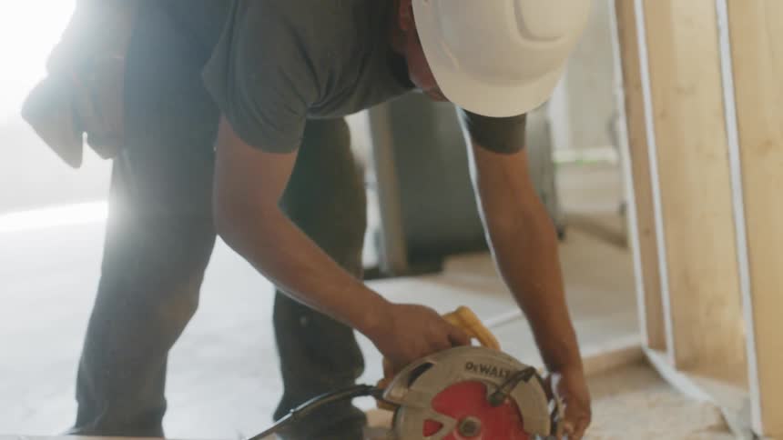 Man uses a skill saw to cut lumber