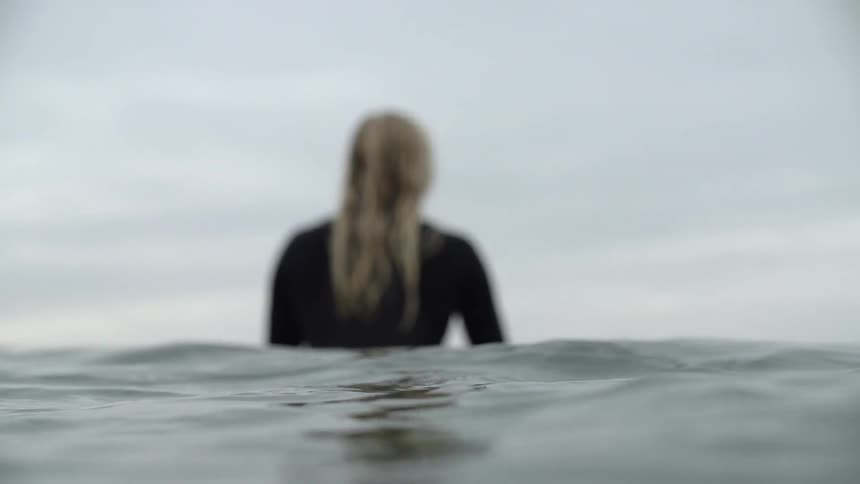 A surfer floats in an ocean