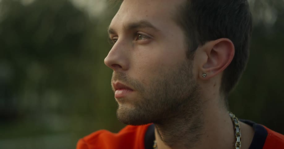 A man looks thoughtful while sitting outside
