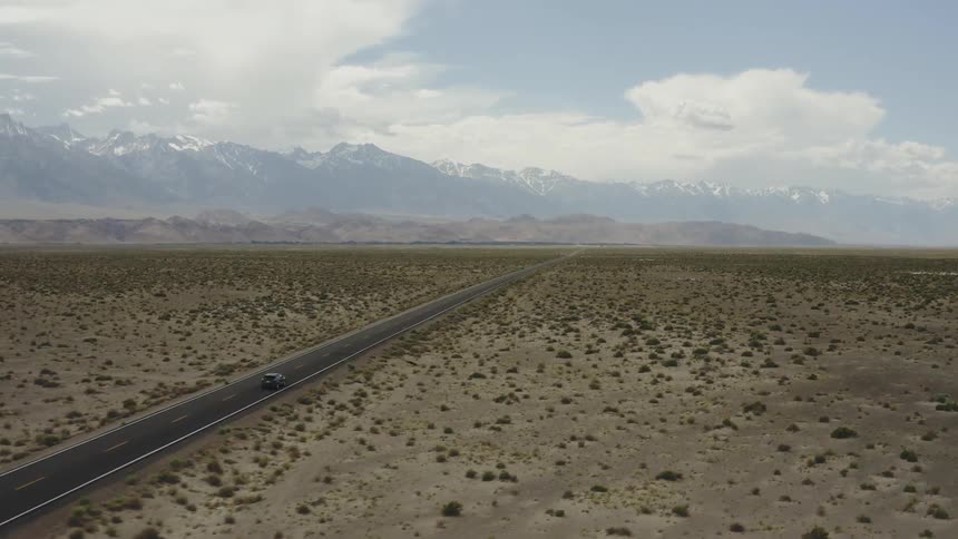 The desert is barren as the car drives past