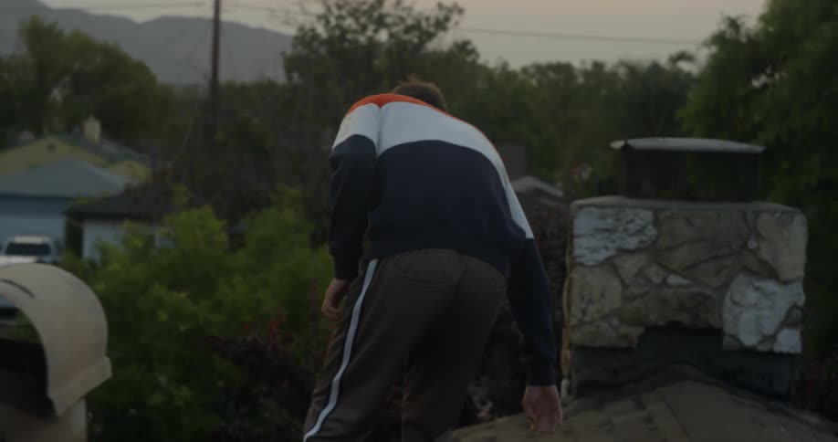 A man walks and sits down on the roof