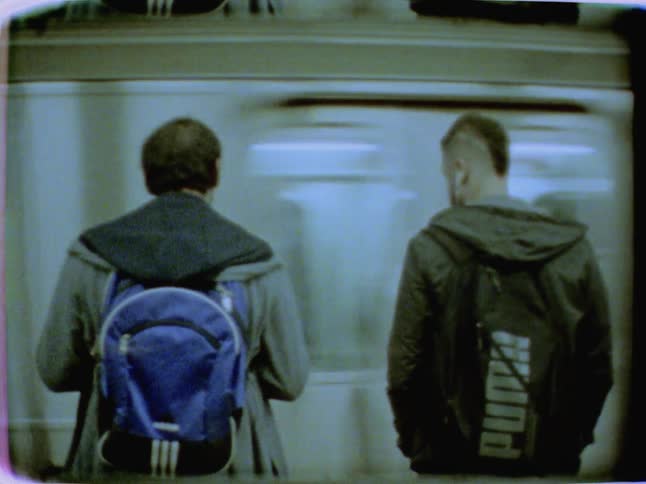 Commuters wait to board a subway