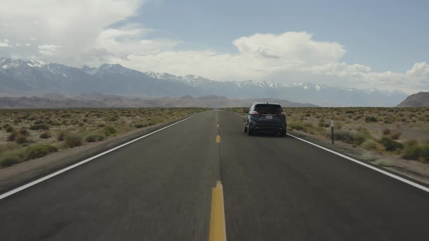 A truck is driven towards the mountains
