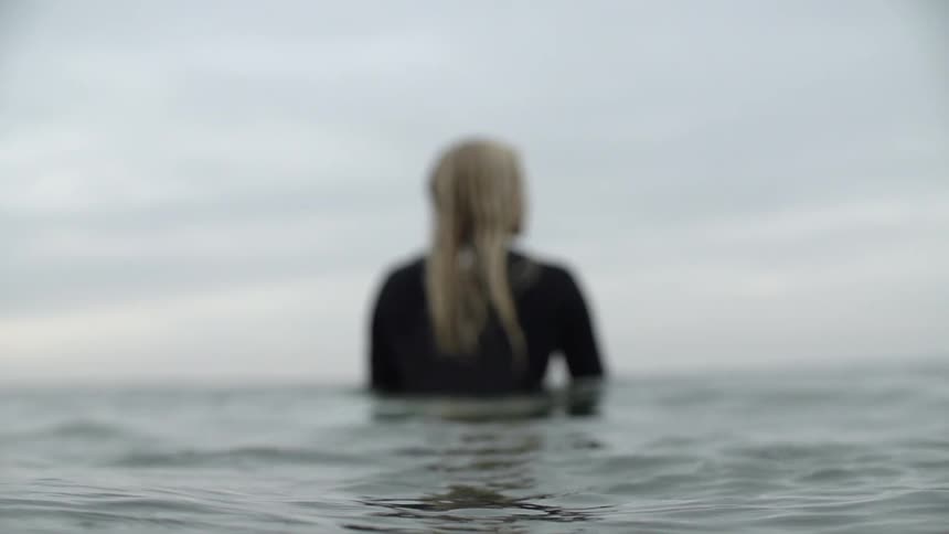 A surfer floats in an ocean