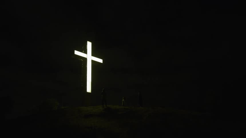 Cross is lit up in the pitch black night