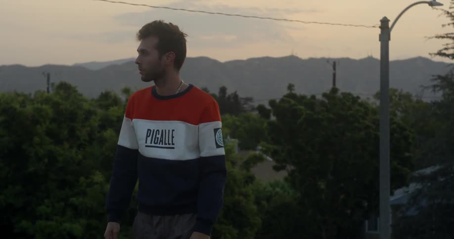 The man looks up towards the mountain at sunset
