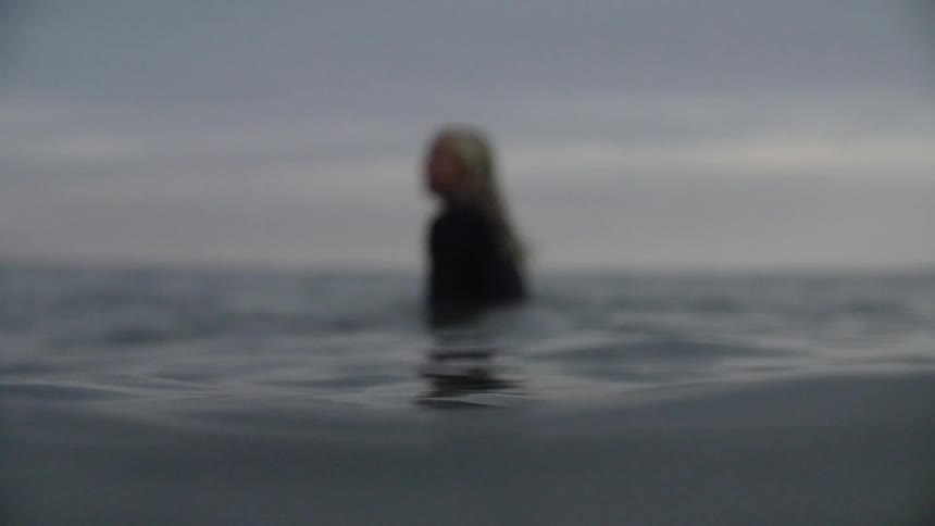 A surfer floats in an ocean
