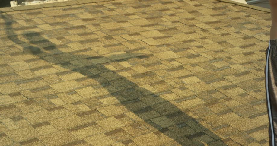 The person is creating a shadow on the roof