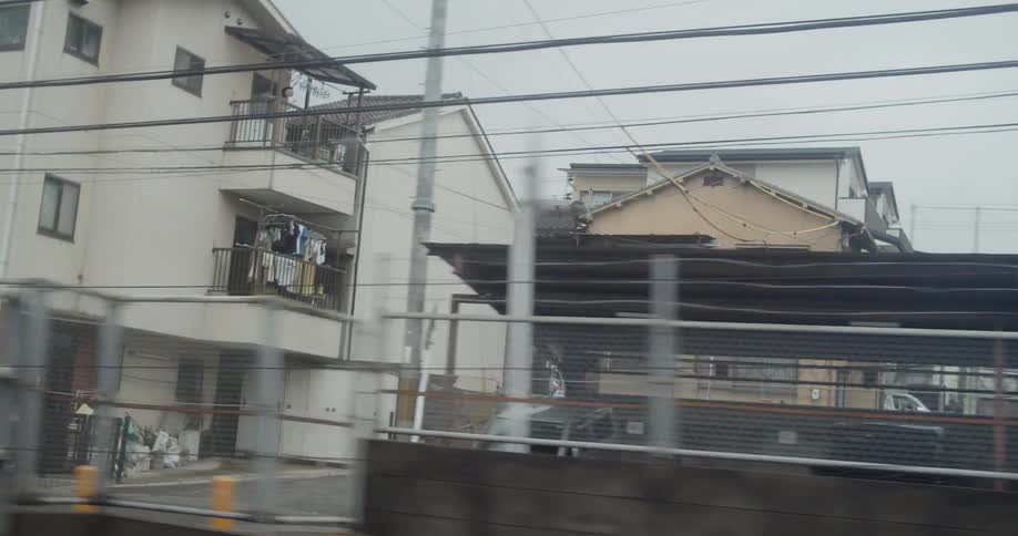 The train is passing the town on a cloudy day