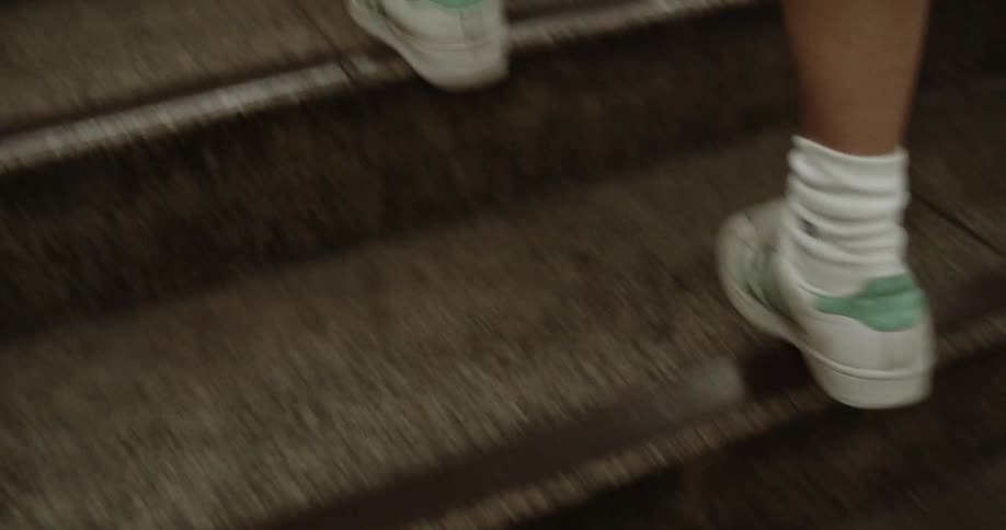Man wearing running shoes climbs the steps