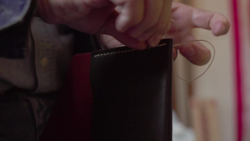 A man stitches leather