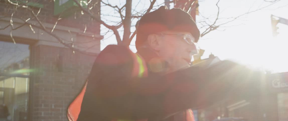 Man wearing a toque and vest punches his arms