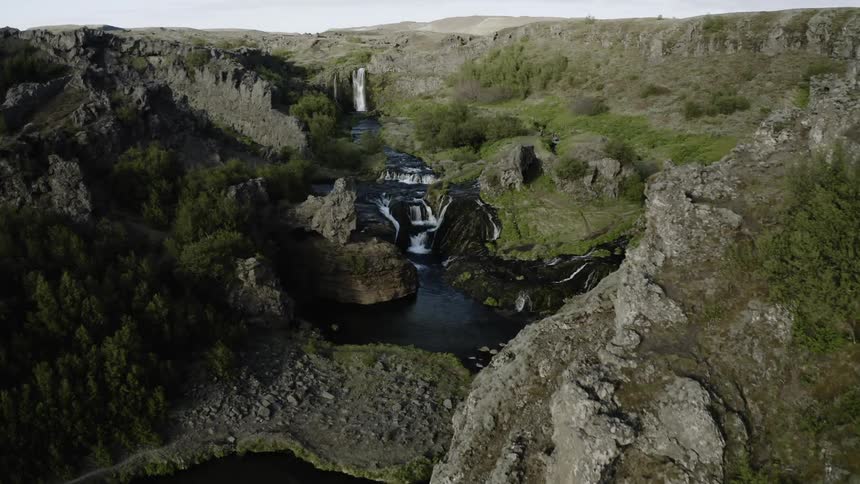 The small pool of water is surrounded by hills