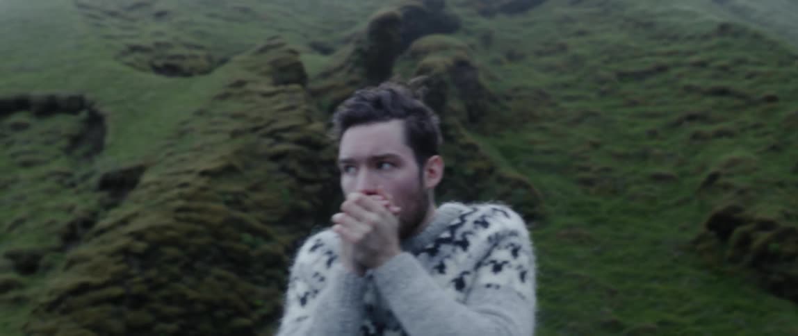 A man rubs his hands together outside