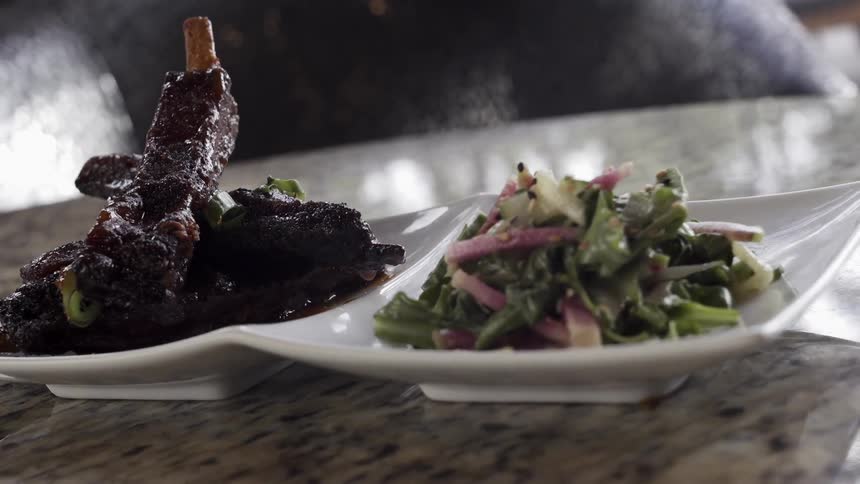 Plate of meat and salad sits on a table