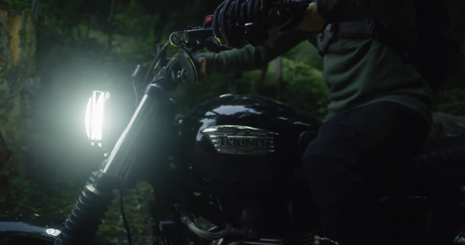 A man rides off on a motorcycle