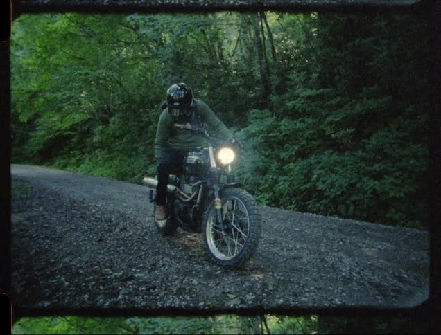 A man rides off on a motorcycle