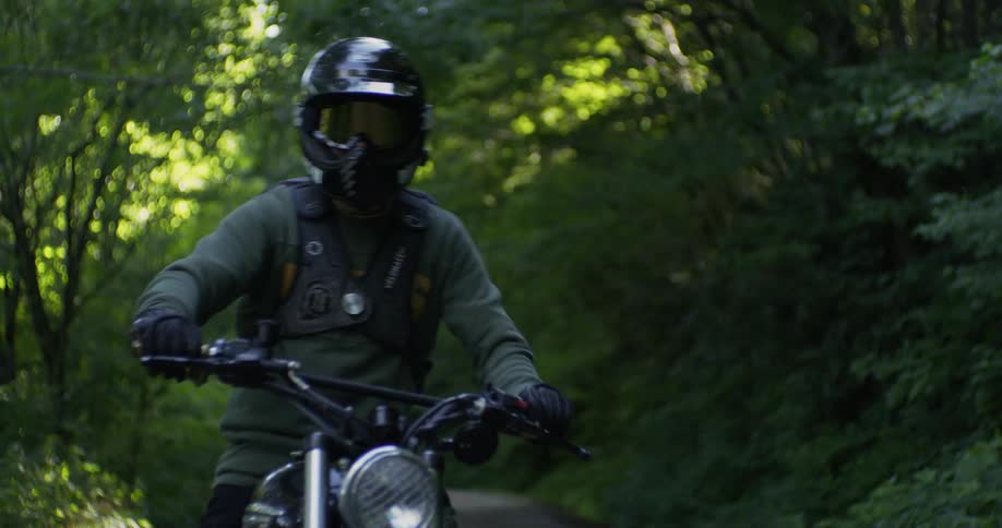 A motorcyclist rides in a forest